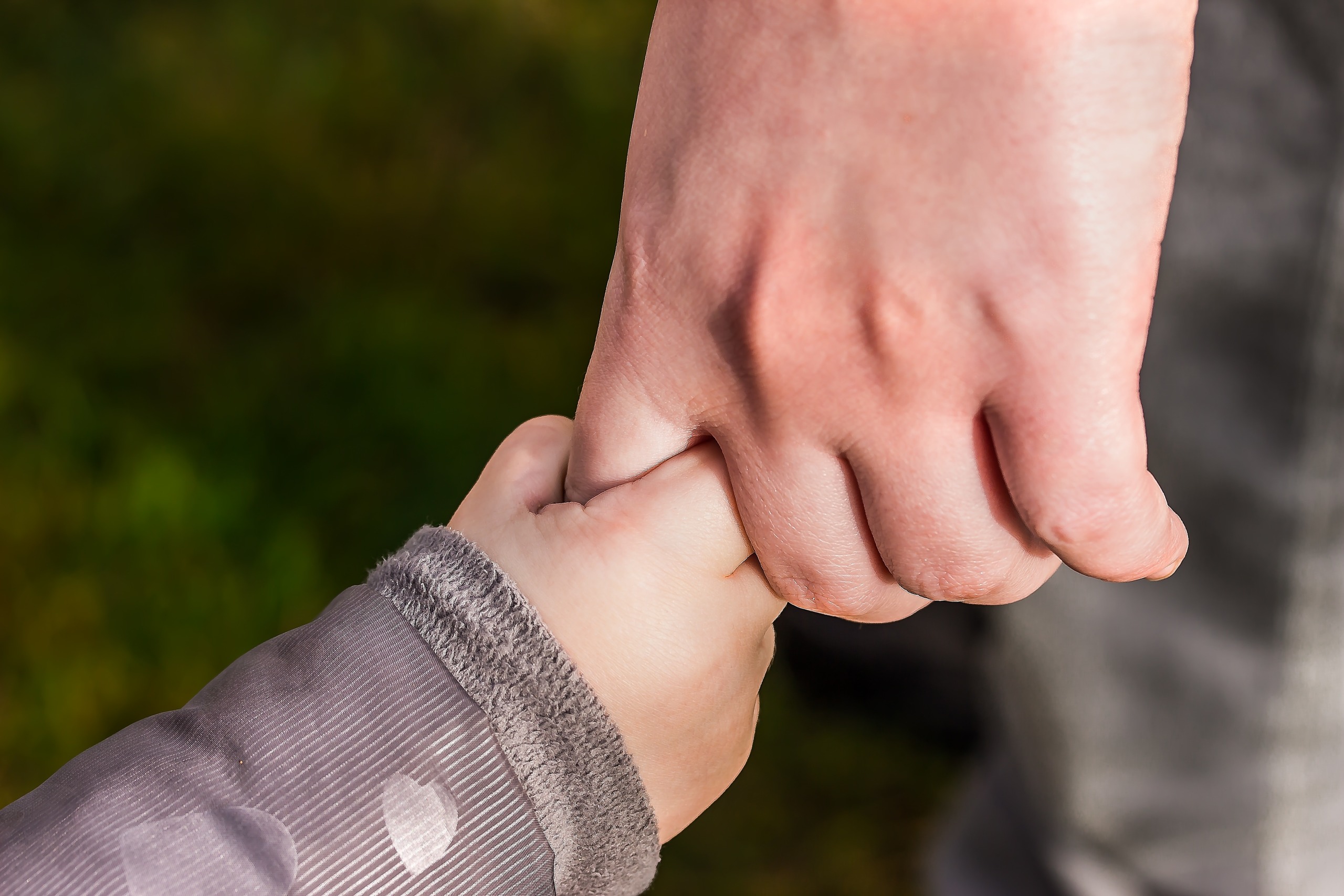 Adult holding child's hand: National Child Abuse Prevention Month